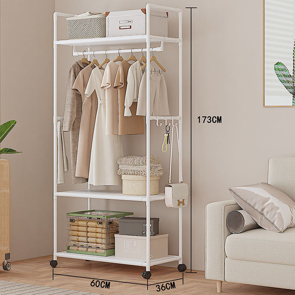 White clothing rack with clothes and storage boxes in a room with a sofa and plant.