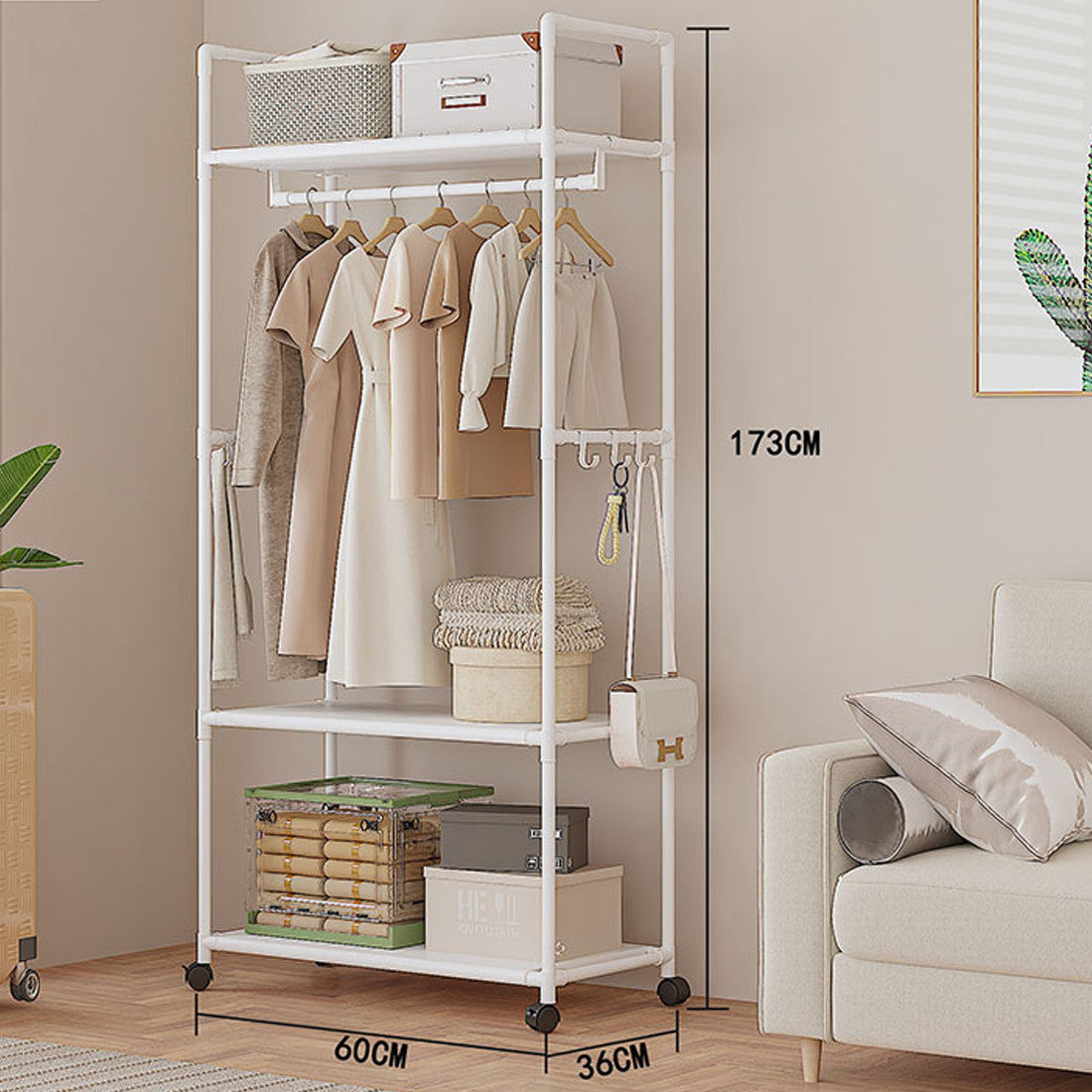 White clothing rack with clothes and storage boxes in a room with a sofa and plant.