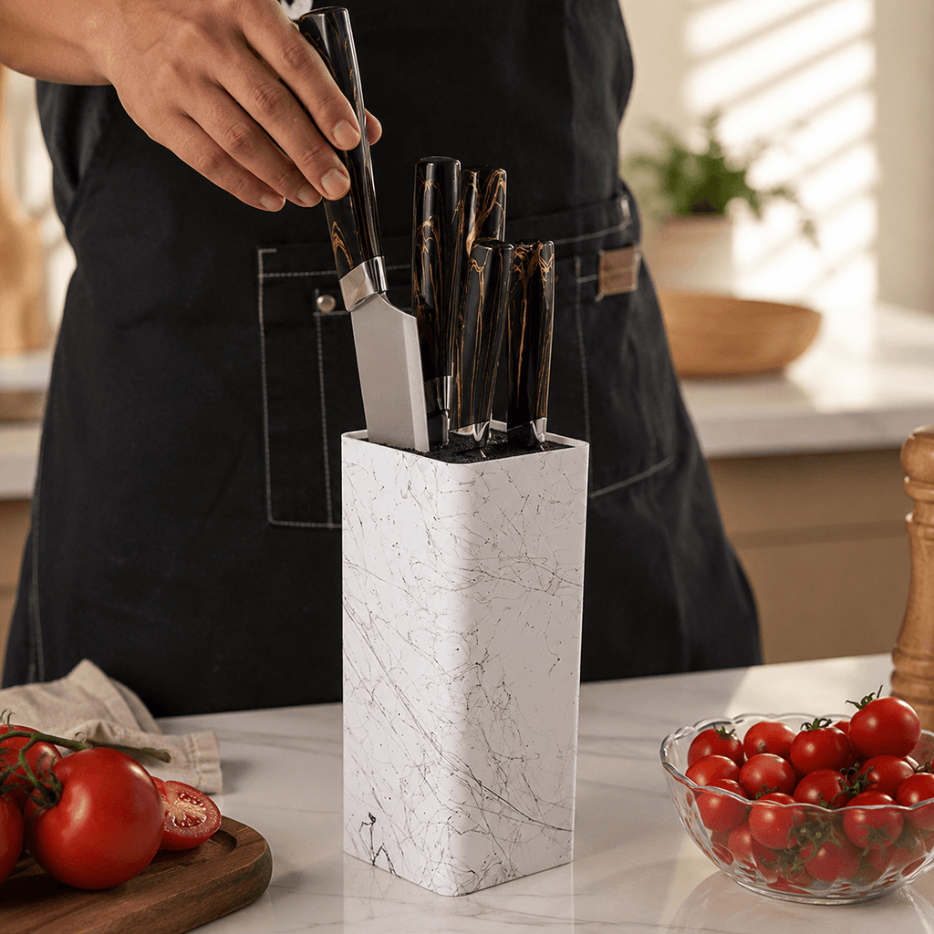 A white marble-patterned knife block holding several kitchen knives.